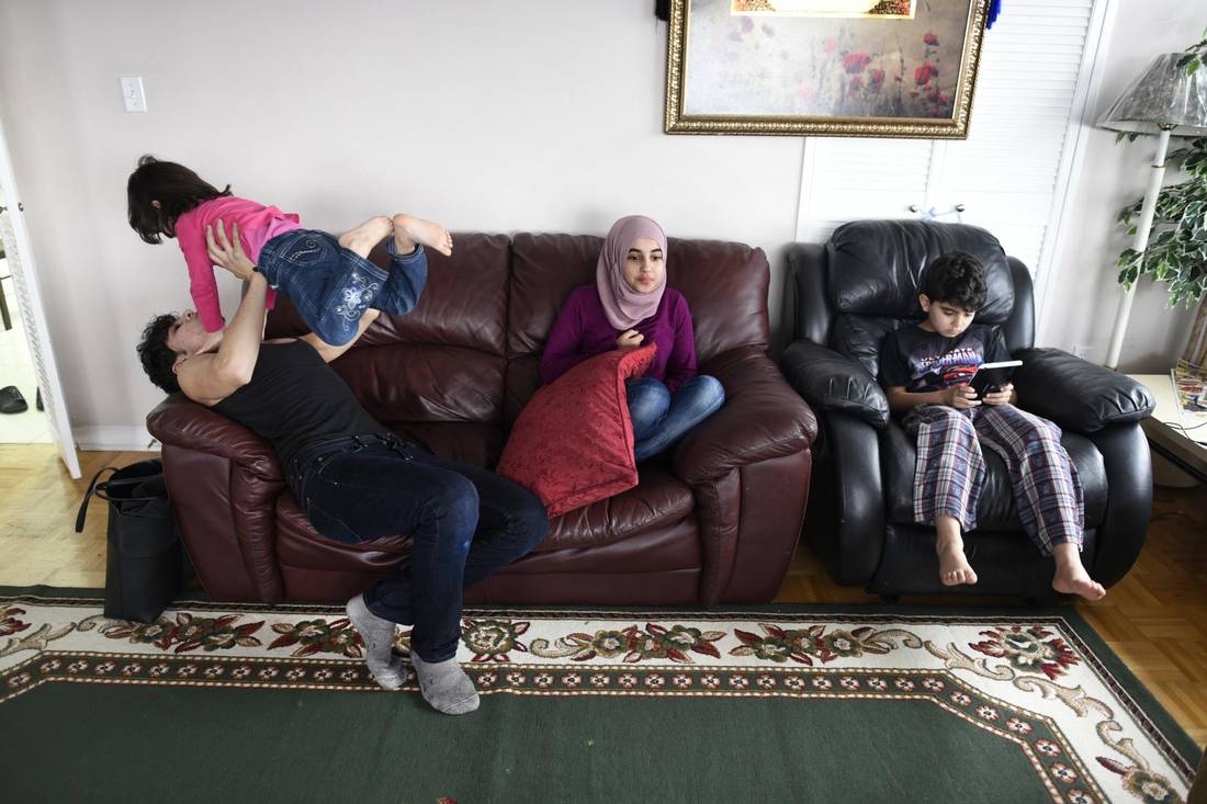 Fifteen-year-old Bilal Al Rasoul tosses his youngest sister, Sava, 3, while sitting with Marwa, 13, and Mohammad, 12, at the family’s Thorncliffe Park home last month.