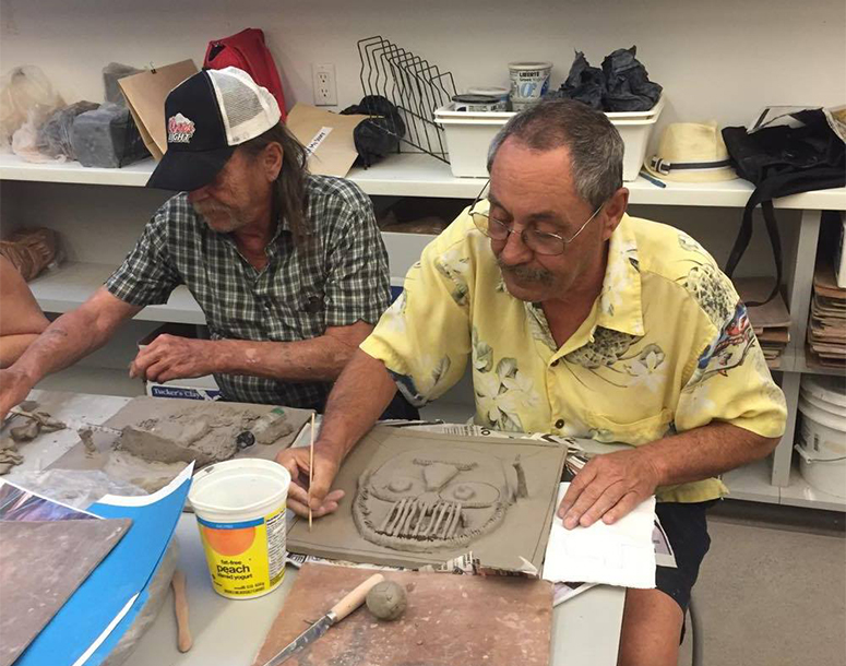 People working with clay to make art