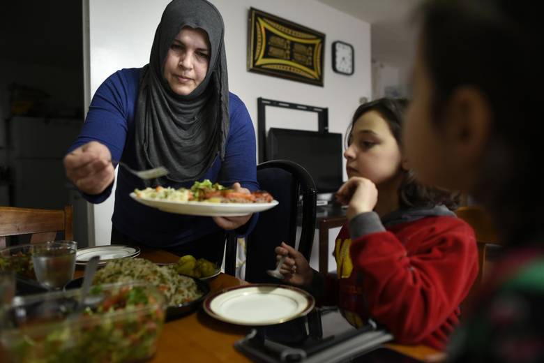 Abir Abdel Al Kader serves a late afternoon meal for her daughters Rama Al Dibel, 9, (C) and Rimas Al Dibel, 6.