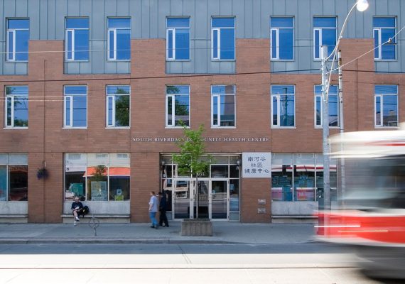 The South Riverdale Community Health Centre building with a streetcar passing by