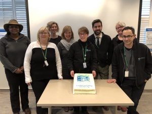 Group of people celebrate with a cake