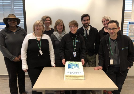 Group of people celebrate with a cake