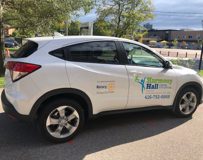 White Honda SUV with Harmony Hall and Rotary Club logos