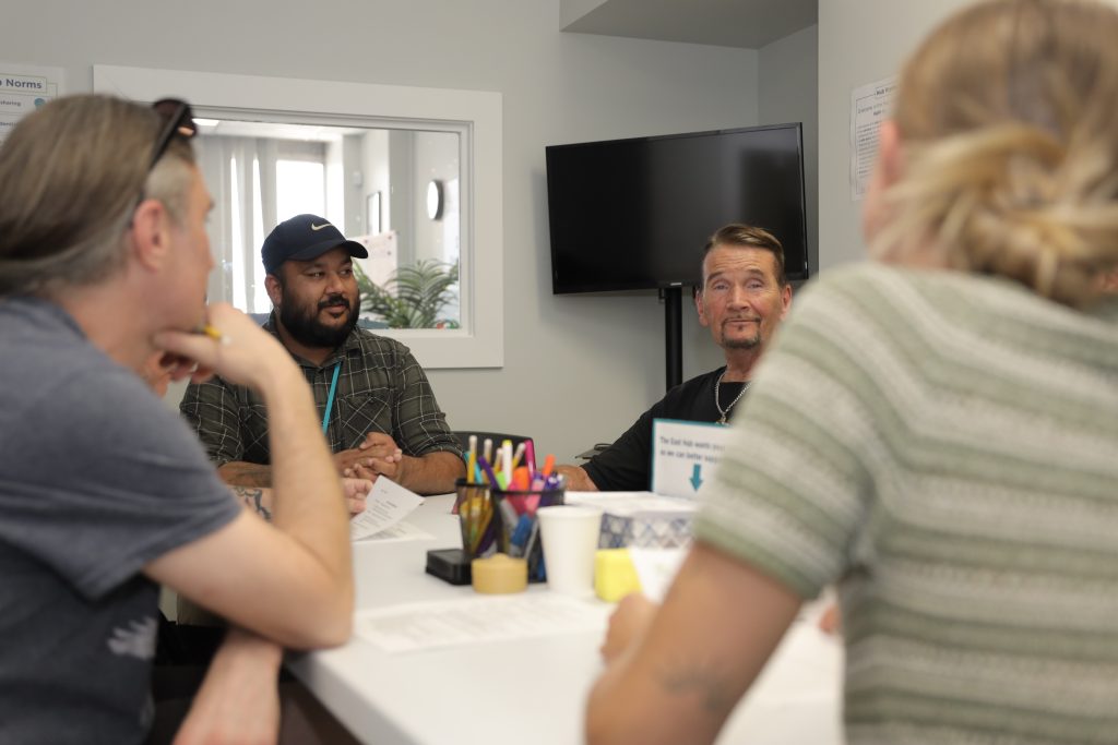Four people sit around a table, having a conversation