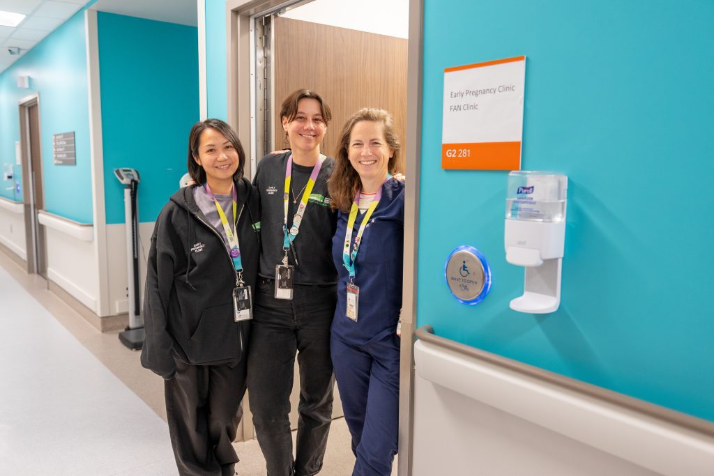 3 members of the MATCH team stand in the doorway of a hospital room