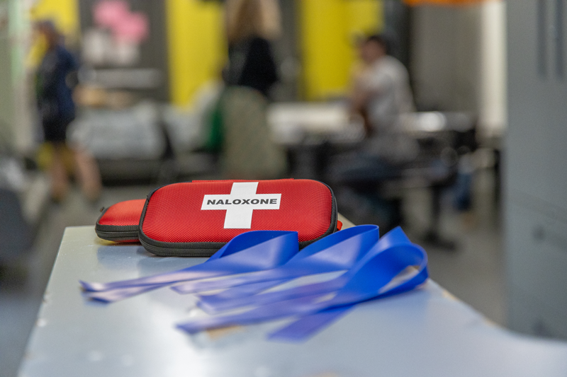A counter with a naloxone kit and safer supply materials