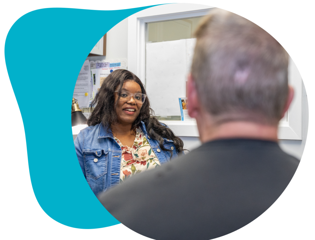 A woman smiles while seated and talking to a client